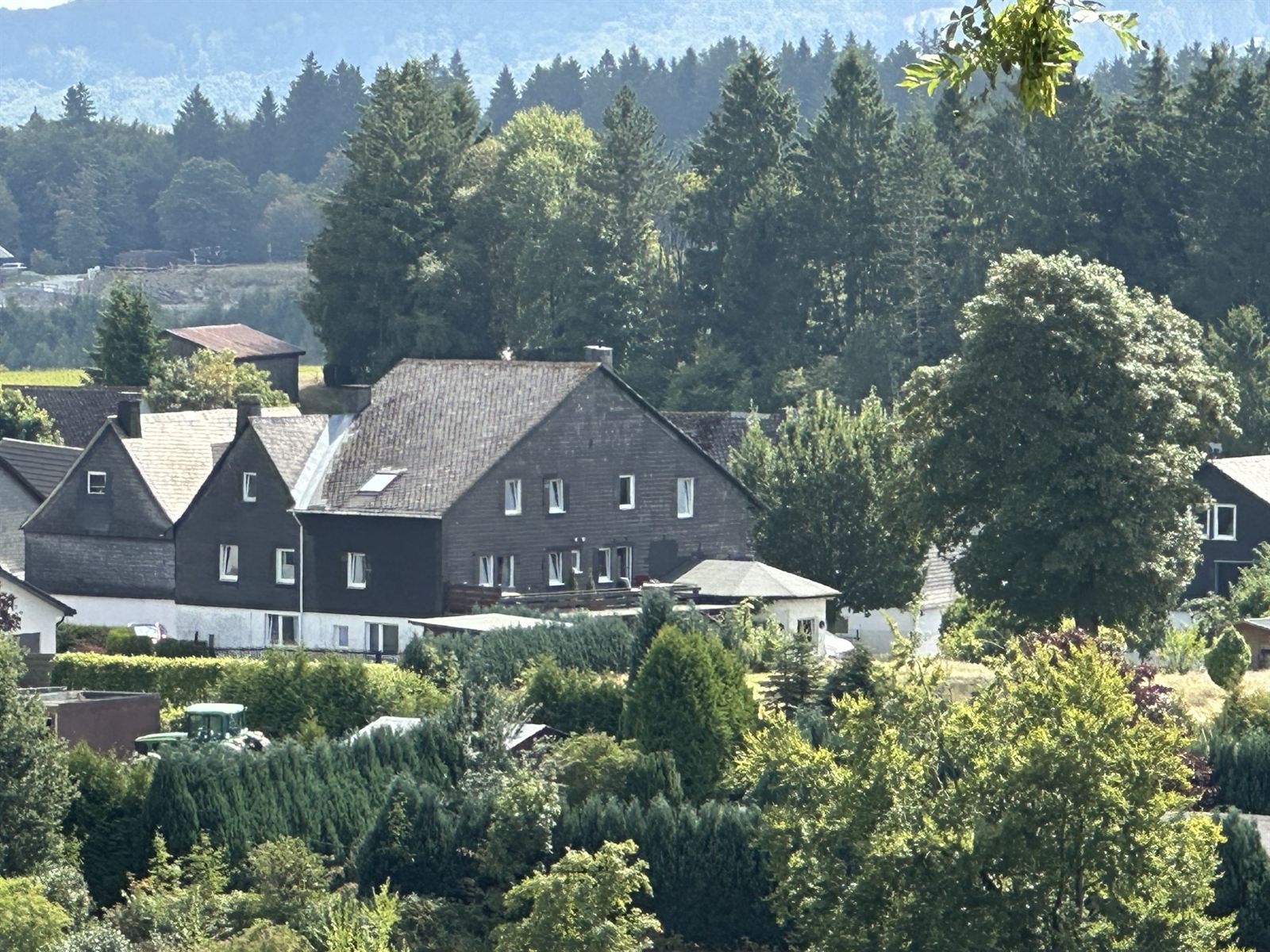 Zomers uitzicht over het dorp en de groene heuvels van het Rothaargebergte